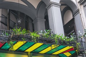 A balcony with plants and a colorful awning. - La Smorfia (Naples)