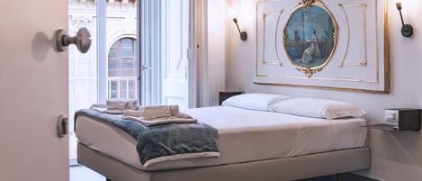 Un dormitorio moderno con una cama grande, un cuadro en la pared y vistas al exterior.