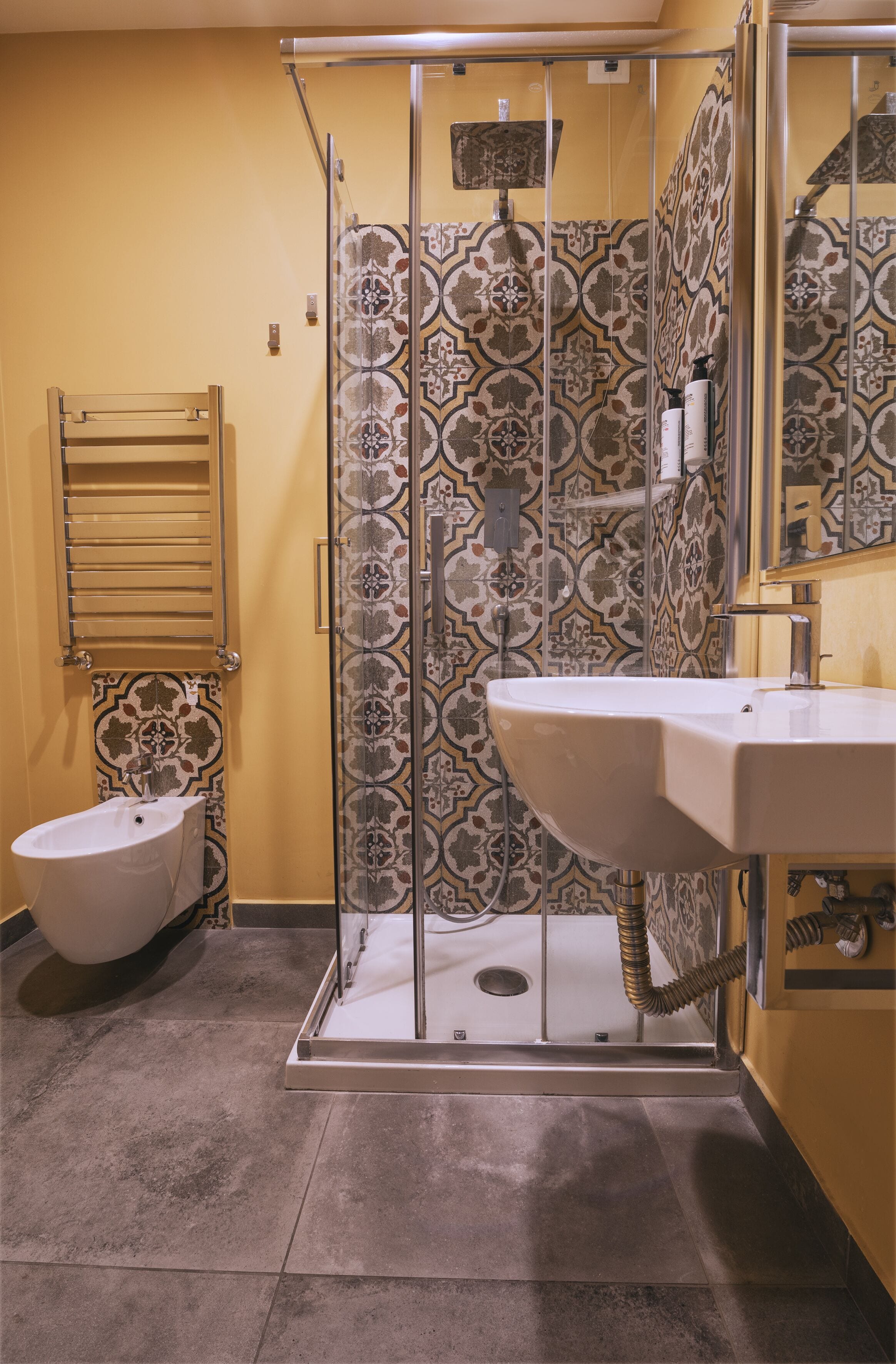 A bathroom with a shower enclosure, a toilet, and a sink.
