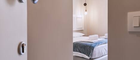 Une chambre à coucher avec un lit, un luminaire suspendu et une porte dotée d’une serrure.