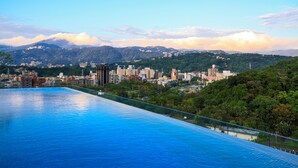 A swimming pool with a cityscape in the background. - Renaissance Taipei Shihlin Hotel (Taipei)
