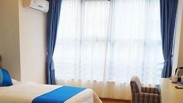 A hotel room with two beds, a desk, and a chair.