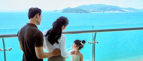 A balcony with a view of the sea and a distant island.