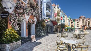 A charming street with a coffee shop named Mama Moon and a building with a unique architectural design.
