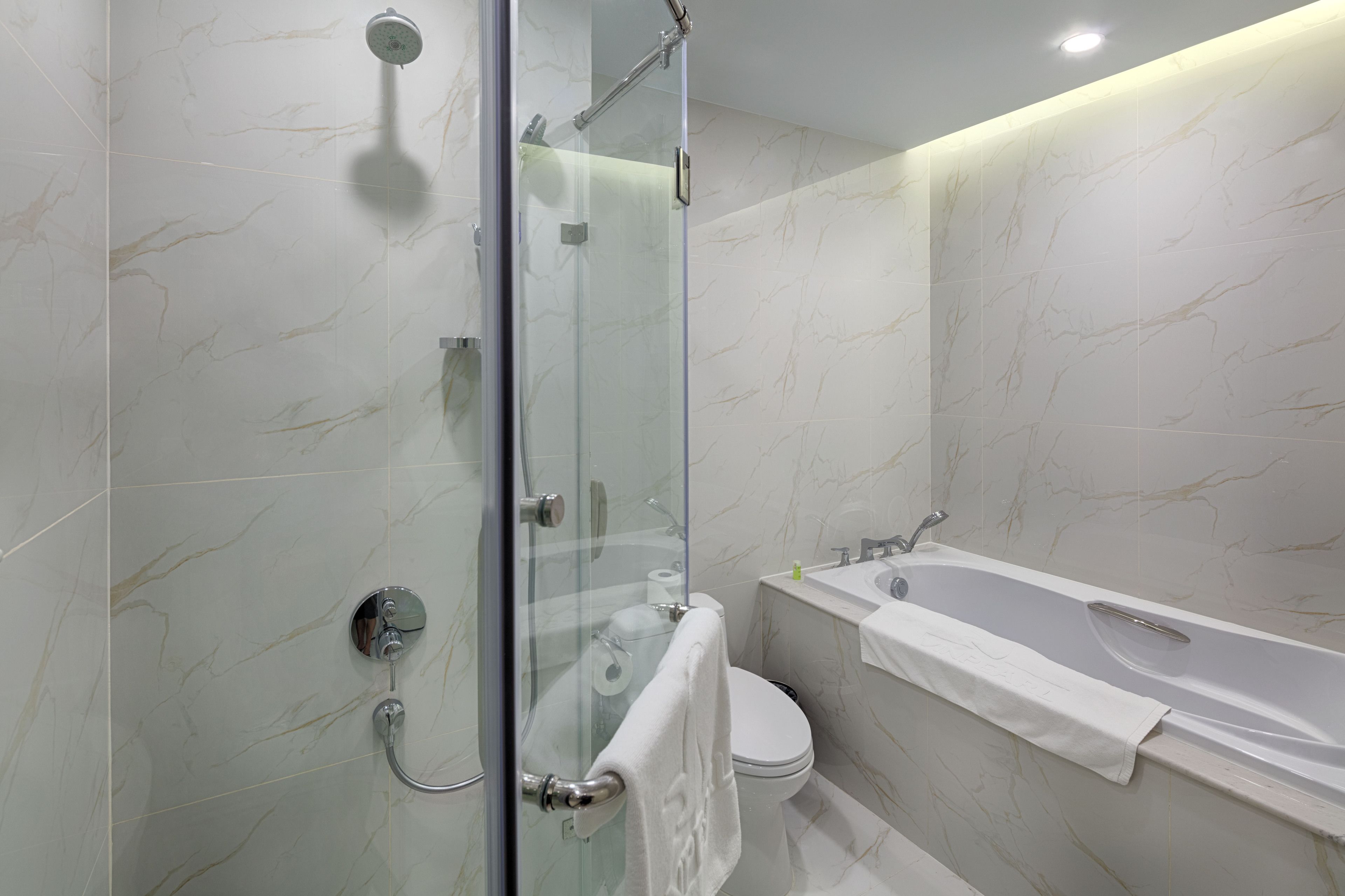 Een moderne badkamer met een douchecabine, toilet en ligbad.