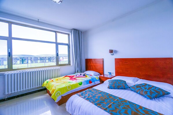 A hotel room with two beds, a large window, and a view of the city. - Yijie Holiday Hotel Fengning Lazhaying (Chengde)