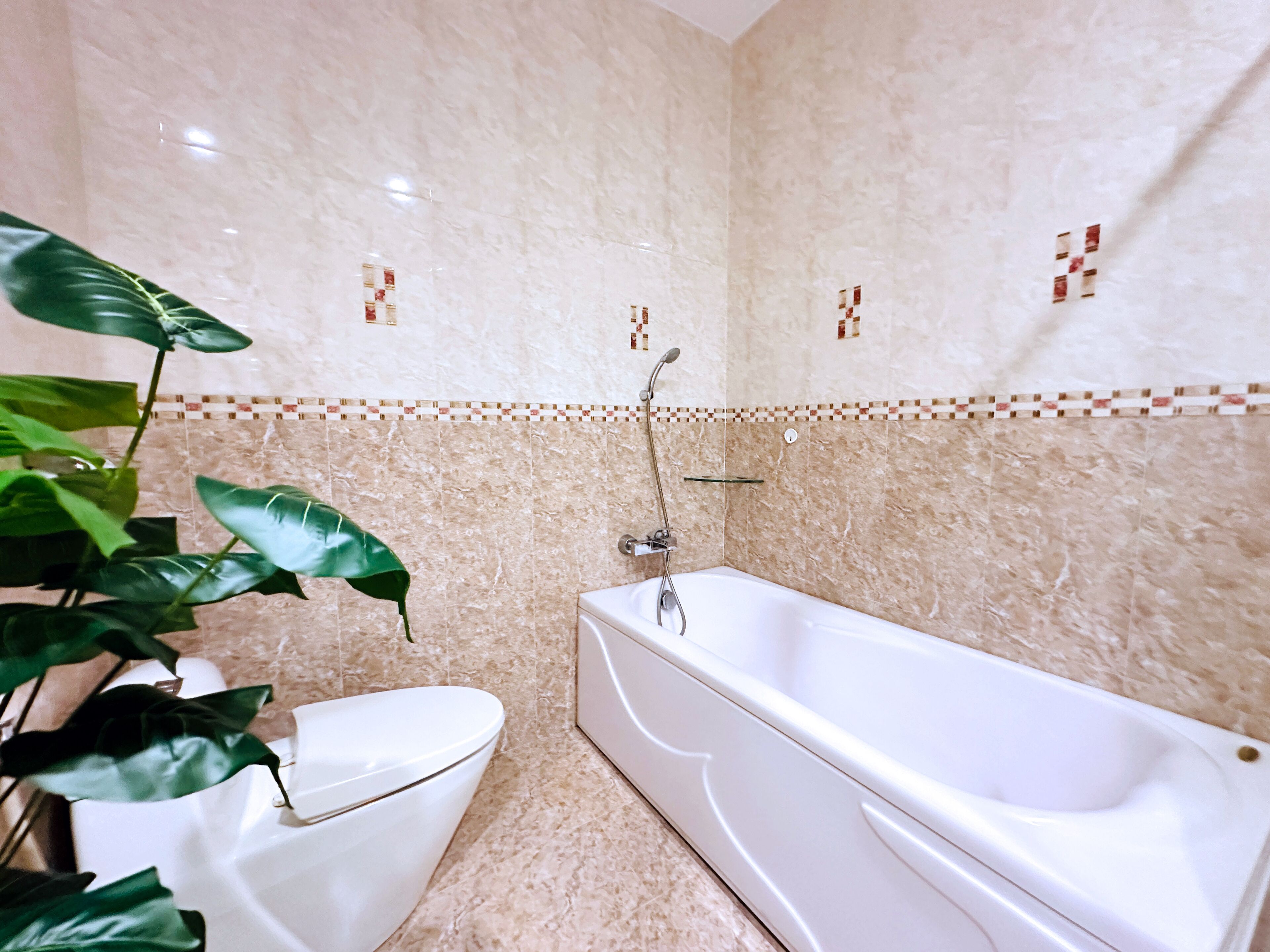 Un baño con bañera, inodoro y ducha.