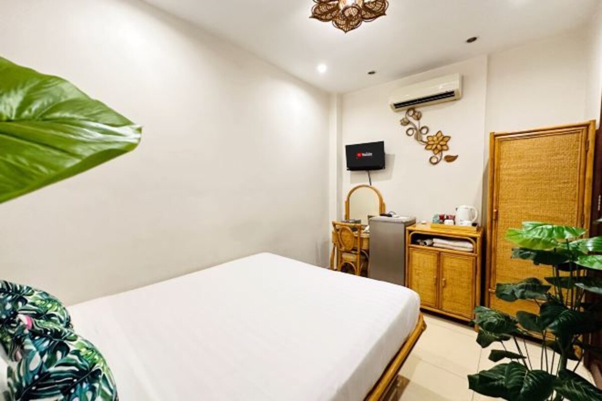 Une chambre d’hôtel comprenant un lit, un bureau avec une chaise, une télévision et une armoire.