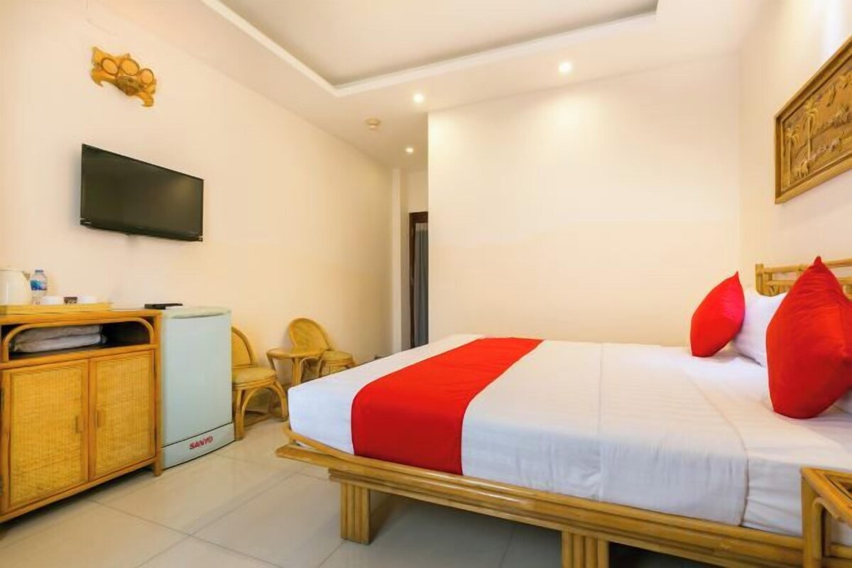 A hotel room with a bed, a television, a desk, and a chair.