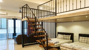 A modern bedroom with a wooden staircase, a bed with plaid bedding, and a large window with sheer curtains. - Kukup Xiang Holiday Home (Kukup)