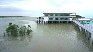 A waterfront hotel with a modern design, featuring a large building with multiple floors and a covered walkway extending into the water. - Kukup Xiang Holiday Home (Kukup)