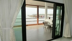 A balcony with a view of the sea and a distant shoreline. - Kukup Xiang Holiday Home (Kukup)
