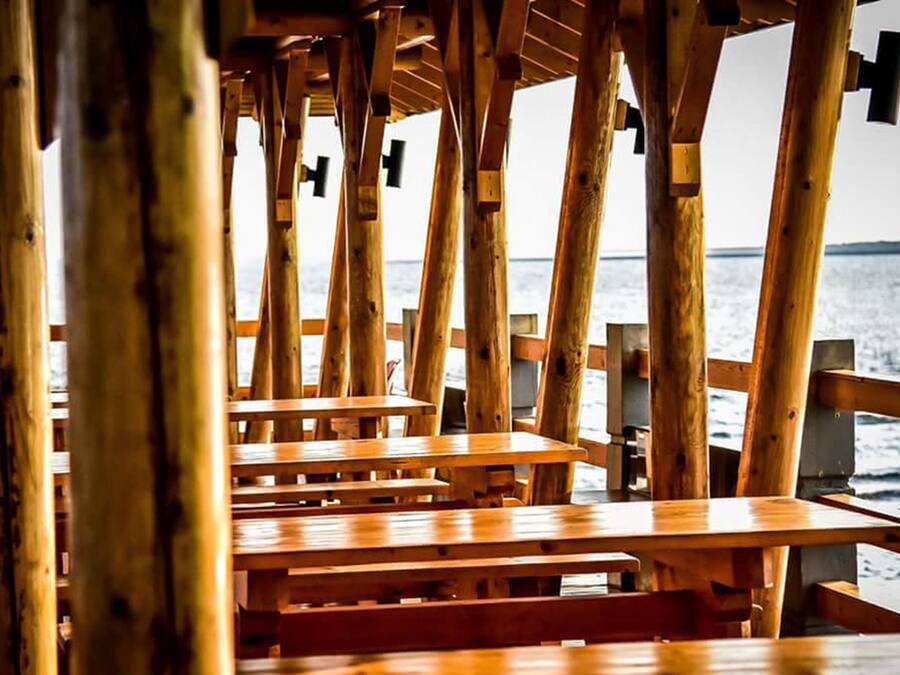 Un pontile in legno con panchine che si affaccia su uno specchio d'acqua.