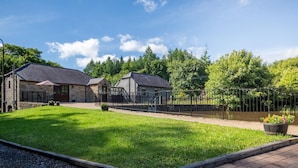 A stone building with a paved walkway and a grassy area. - Tully Mill Cottages (Enniskillen)