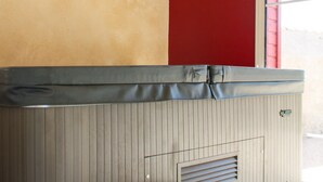 A room with a wooden ceiling, a beige wall, and a red wall. There is a bench and a window with blinds. - Le Puy Carmin - Chambres D'hôtes (Bazoges-en-Paillers)
