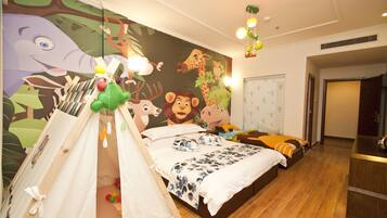 A bedroom with a large mural, a tent-like play area, a bed with multiple pillows, and a nightstand.