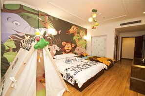Un dormitorio con un mural grande, una zona de juegos tipo tienda de campaña, una cama con muchas almohadas y una mesita de noche.