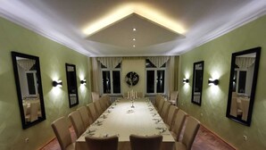 A conference room with a long table, chairs, and wall-mounted lights.