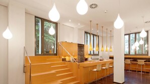 Un intérieur moderne avec un escalier, un coin bar et des espaces pour s’asseoir.