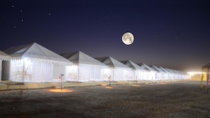 A row of white tents with a moon in the sky. - Shiv Tara Desert Camp (Jaisalmer)