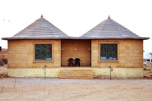 A two-story wooden building with a symmetrical roof and a central entrance. - Shiv Tara Desert Camp (Jaisalmer)