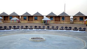 A row of simple, single-story buildings with pitched roofs, arranged in a linear fashion. - Shiv Tara Desert Camp (Jaisalmer)