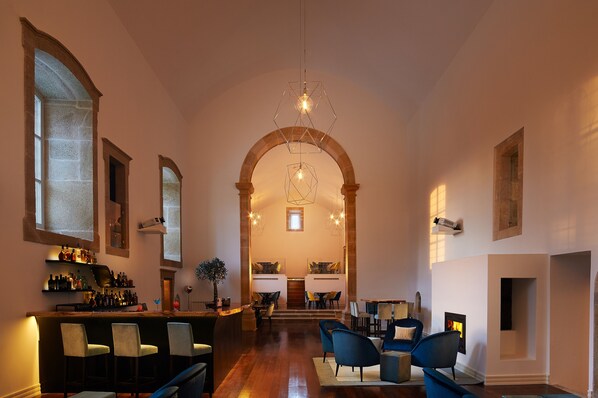 A spacious interior with a bar area, seating, and a fireplace. - Convento do Seixo Boutique Hotel & Spa (Fundao)