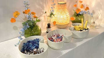 A table with decorative items including vases with flowers, a lantern, and bowls of candies.