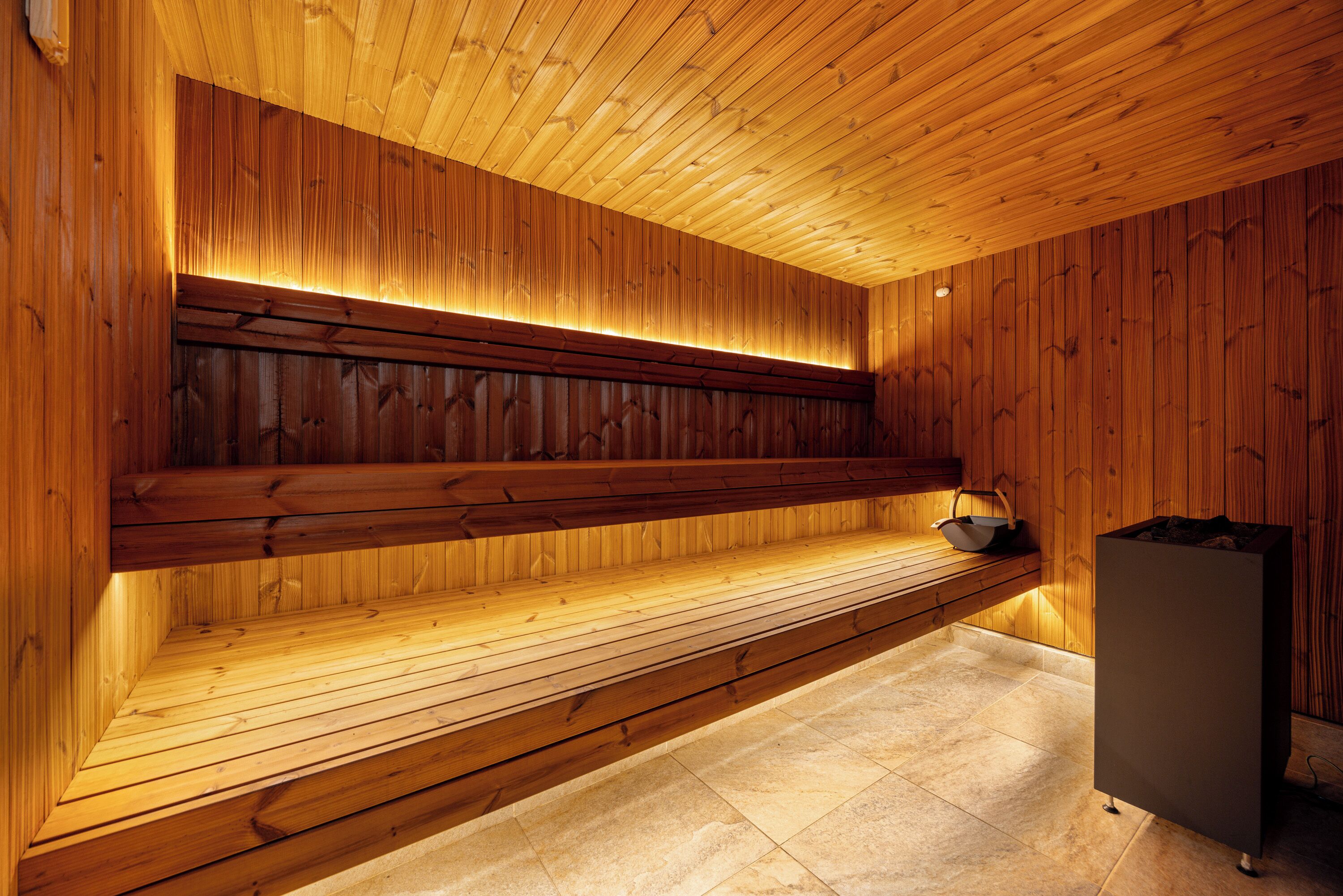 A wooden interior with a bench, a tiled floor, and a cabinet.