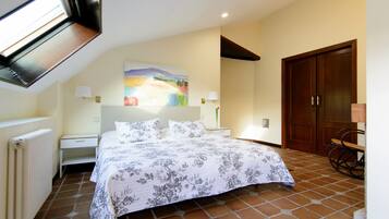 Un dormitorio con una cama grande, una mesita de noche, una lámpara, una puerta de madera y una ventana.