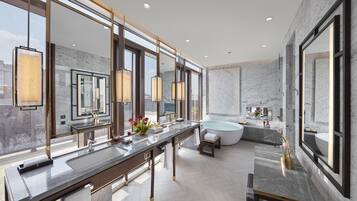 A modern bathroom with a large vanity, a bathtub, and a large mirror.