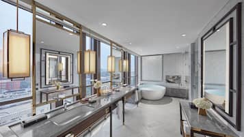 A modern bathroom with a large vanity, a bathtub, and a large mirror.