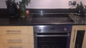 Eine Küche mit integriertem Backofen, einer digitalen Uhr und einer Kaffeemaschine.