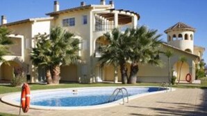 A large, two-story building with a swimming pool in front. - Villages Golf Panoramica (San Jorge)