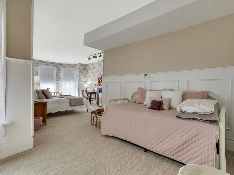 Um quarto com uma cama, uma escrivaninha e uma cadeira.