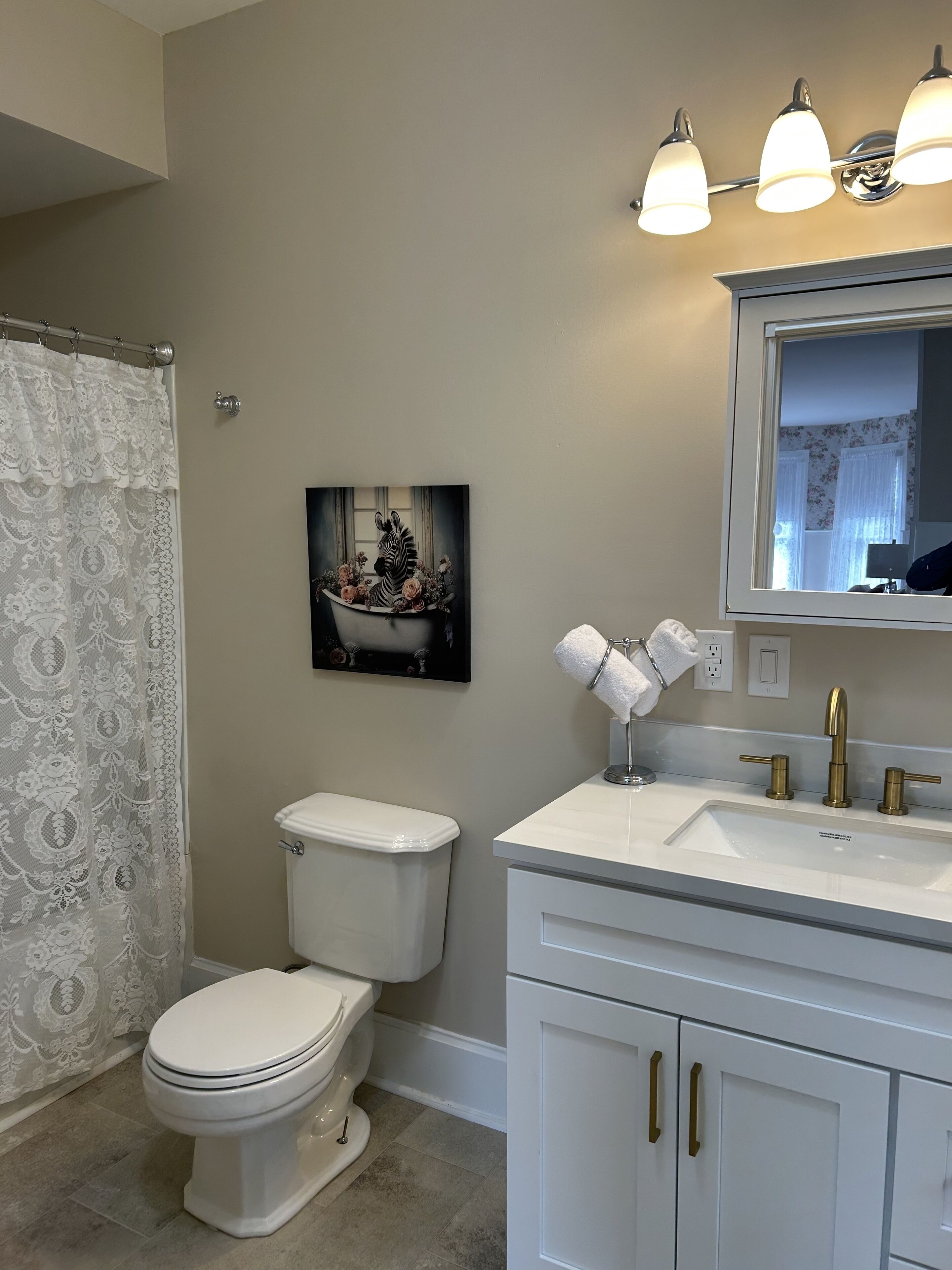 A bathroom with a toilet, sink, and shower curtain.