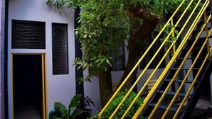 A staircase with yellow railings leading to a door with a window. - Hotel el Sole - Hostel (Santa Ana)