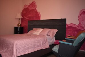 A bedroom with a bed, a nightstand, a lamp, and a chair. - Hotel el Sole - Hostel (Santa Ana)
