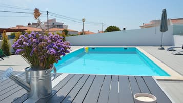 Alberca al aire libre y camastros