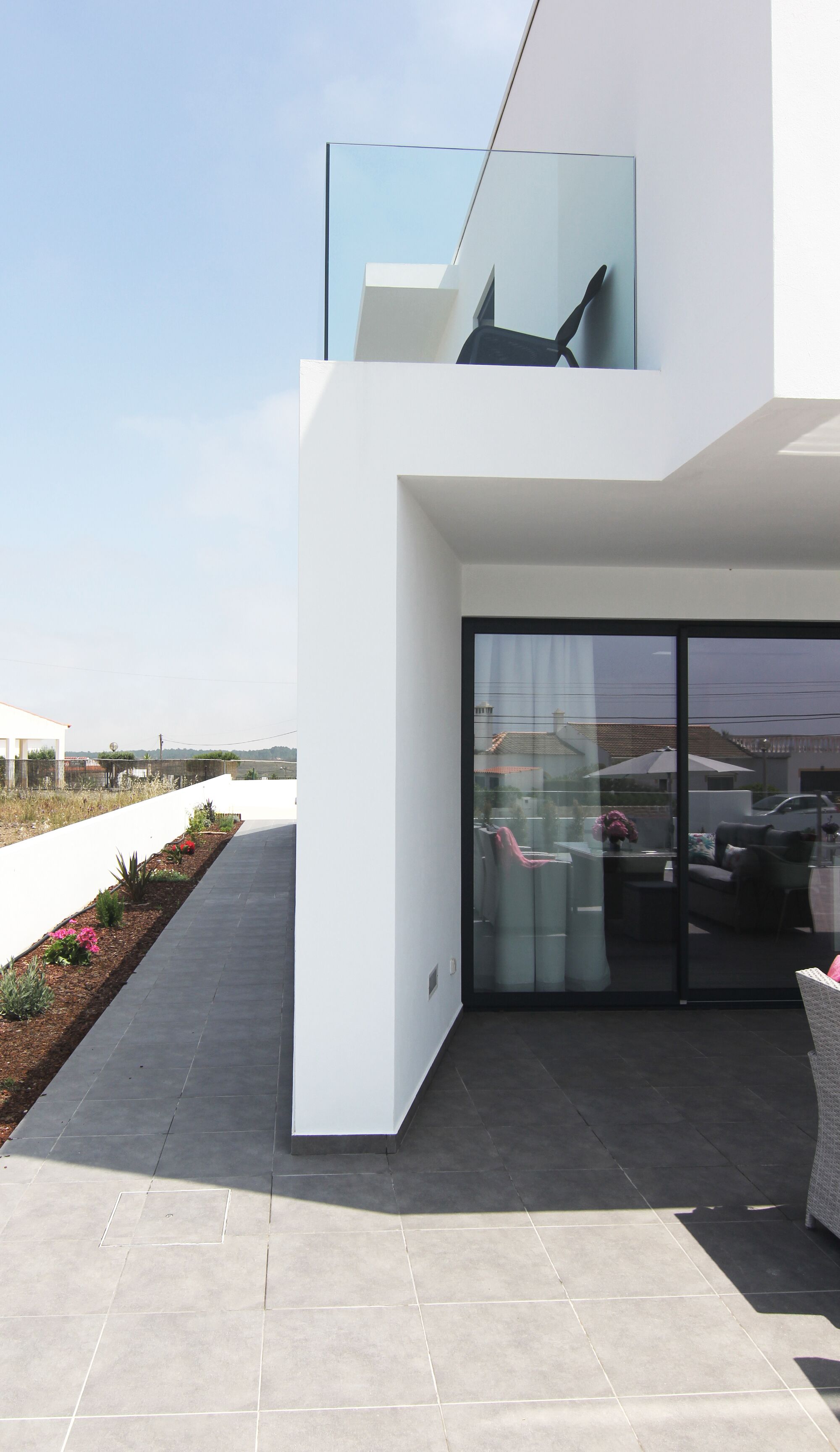 Une maison moderne avec une porte vitrée donnant sur un patio.