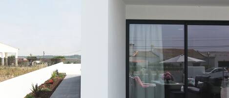 Une maison moderne avec une porte vitrée donnant sur un patio.