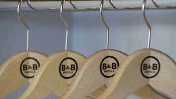 Des cintres en bois portant le logo « B&B HOTELS » sur un présentoir en métal.