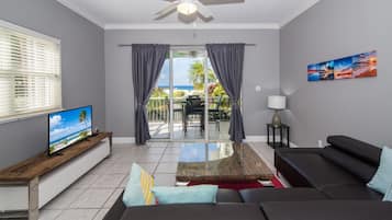 Deluxe Condo, Patio, Sea View | Ruang tamu | TV skrin rata, pemain DVD