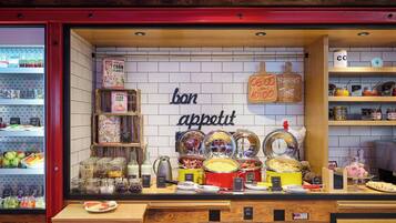 Un buffet de petit-déjeuner proposant une variété d’aliments, accompagné d’une pancarte sur laquelle on peut lire : « Bon appétit ».