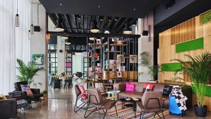 Un vestíbulo moderno con una zona de estar, un mostrador de recepción y una estantería.