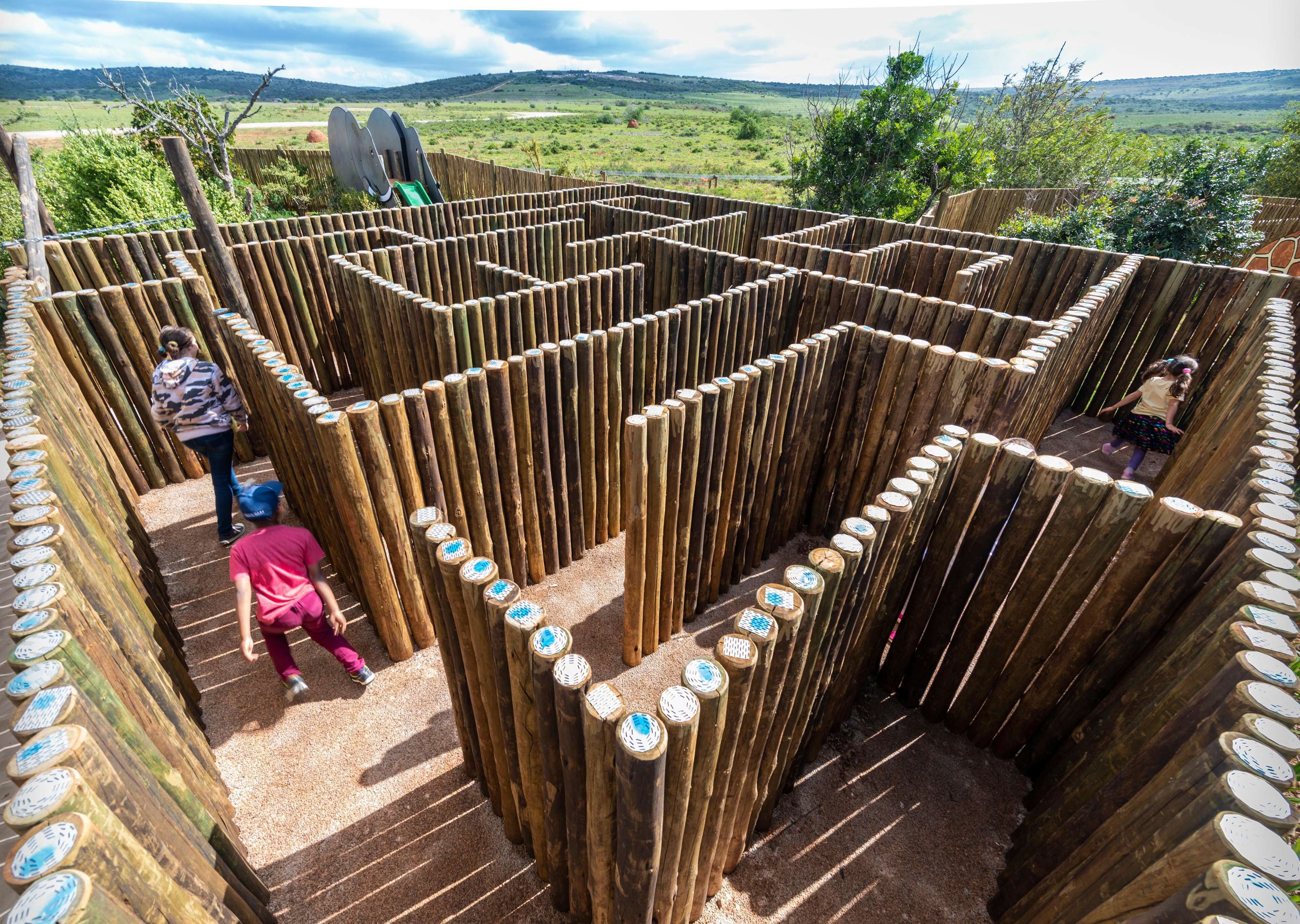 A wooden maze with a clear path, surrounded by a fence.
