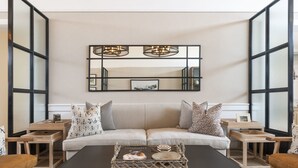 Uma sala de estar moderna com sofá, mesa de centro e mesas laterais.
