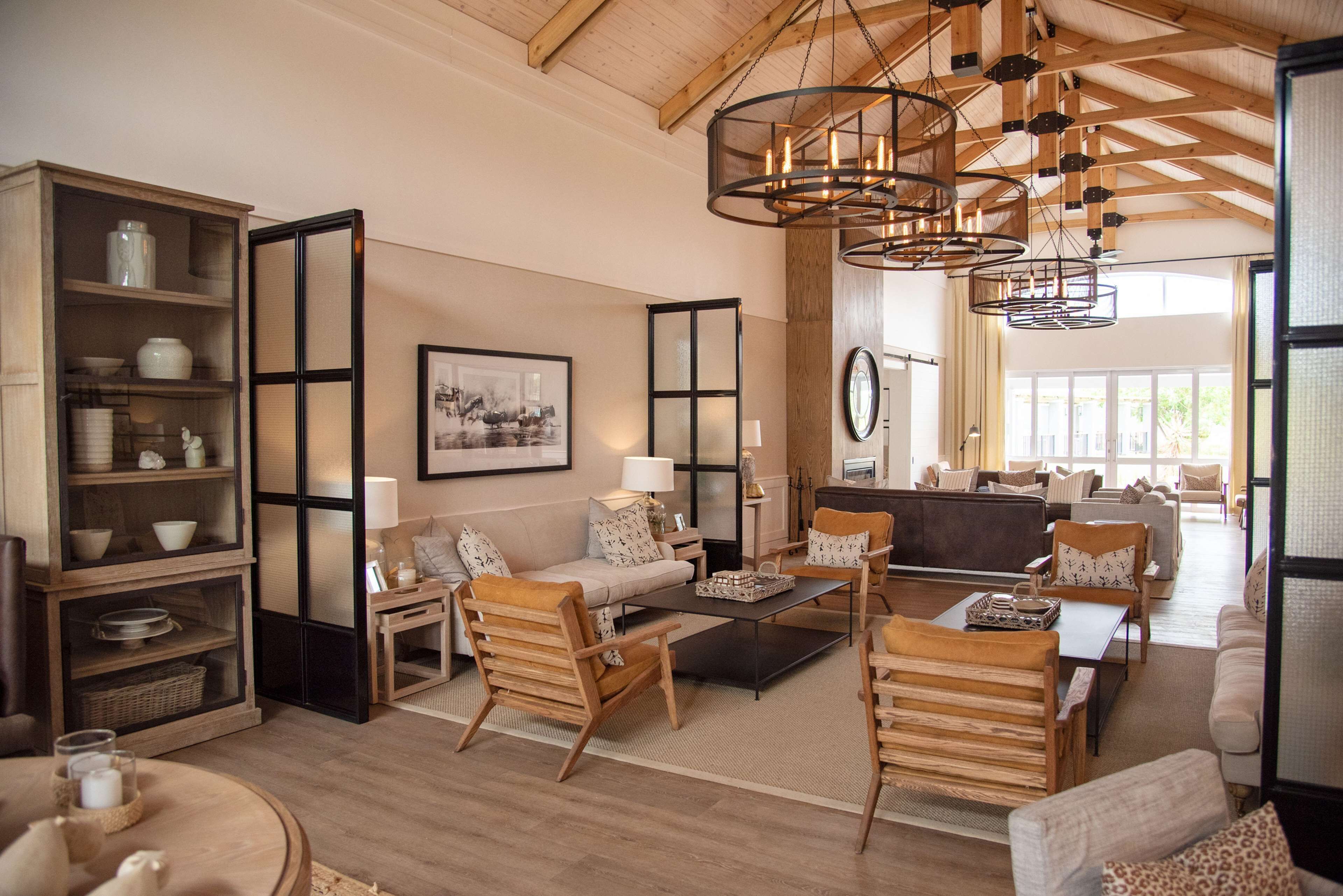 Amplia sala de estar con techo alto, muebles de madera y chimenea.