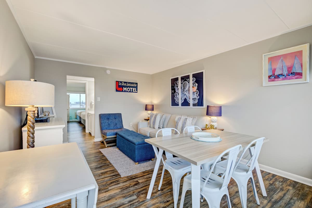 Una habitación de hotel moderna con comedor, un sofá y un cartel que dice 'The Sensible Motel'.