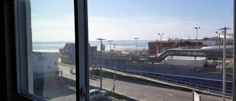 Vista desde una ventana con vistas al mar, un puente, una calle y edificios.